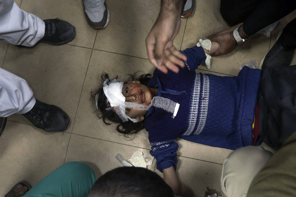 Un bambino ferito in un bombardamento israeliano è trasportato in un ospedale della striscia di Gaza, 25 marzo 2024. © AP/Ismael Abu Dayyah.